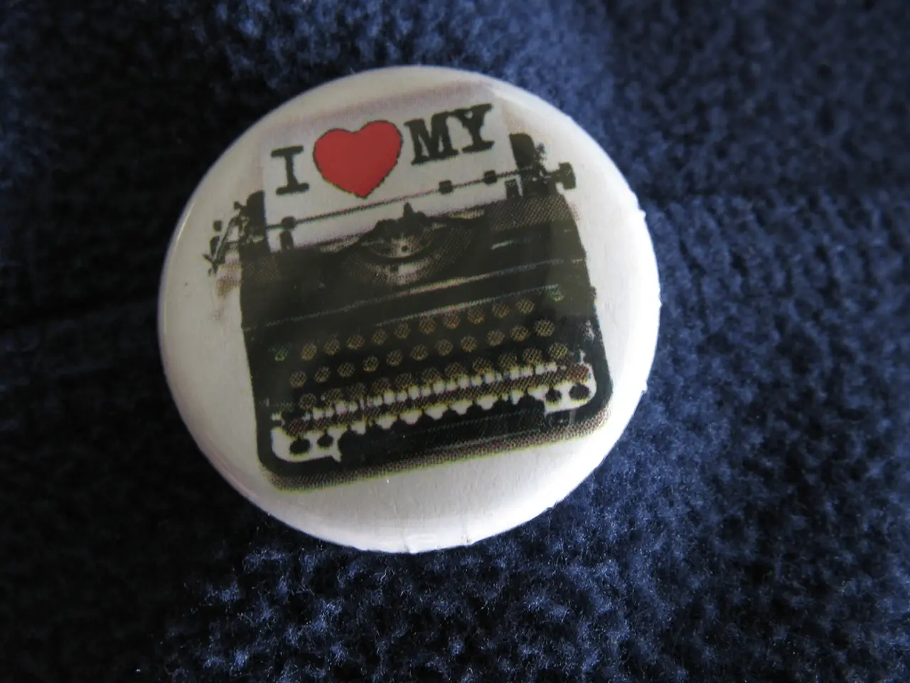 In this picture it looks like a badge with a typewriter image on it.