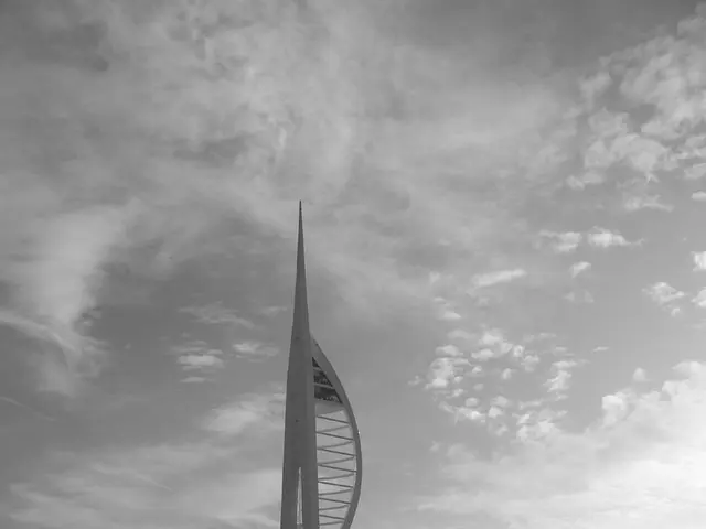 In this picture I can see there is a building and there is a ocean, there are few boats and ships...